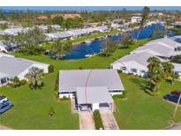 Aerial view of a charming waterfront home with a carport and well-manicured lawn at 4411 Mount Vernon Dr, Bradenton, FL 34210