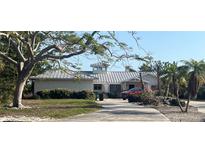 Charming single-story home with a light metal roof, lush landscaping, and a long driveway at 539 Key Royale Dr, Holmes Beach, FL 34217