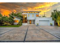 Contemporary two-story home featuring a clean facade, oversized windows, and an expansive concrete driveway at 587 47Th St, Sarasota, FL 34234