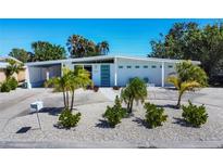 Charming single-story home featuring a modern design, well-kept landscaping, and a inviting blue front door at 6731 Northampton Pl, Bradenton, FL 34207