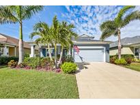 Charming single-story home boasts a two-car garage, a lush lawn with tropical landscaping, and a paver driveway at 7012 White Willow Ct, Sarasota, FL 34243