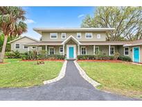 Charming two-story home featuring a welcoming front porch and a beautifully landscaped front yard at 730 Rellim Ln, Sarasota, FL 34232