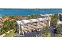 Beautiful condo building with lush landscaping and ample parking, near bay and other residential buildings at 8625 Midnight Pass Rd # 305B, Siesta Key, FL 34242