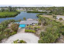 Waterfront home features a private dock, tiki hut, pool and lovely landscaping at 1410 San Jose Dr, Englewood, FL 34223