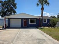 Charming single-Gathering home with a well-maintained lawn, attached garage, and a beautiful palm tree at 14914 Old Dixie Hwy, Hudson, FL 34667