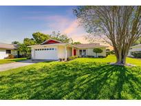 Charming single-story home with a well-manicured lawn and mature landscaping creating curb appeal at 1525 Fleetwood Dr, Sarasota, FL 34232