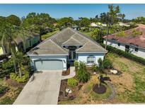 An aerial view of a single-story home with a gray tiled roof and well manicured yard at 2311 Falcon Trace Ln, Nokomis, FL 34275