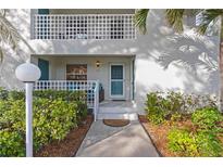 Picture perfect condo entrance with meticulous landscaping, outdoor seating, and a welcoming entrance at 321 108Th W St # 120, Bradenton, FL 34209