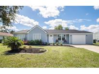Charming one-story home with a well-manicured lawn and inviting curb appeal on a sunny day at 4493 Mckibben Dr, North Port, FL 34287