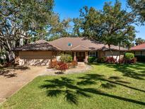 Charming single-story home with a tile roof, mature trees and a well-manicured lawn and a two car garage at 4701 Pine Harrier Dr, Sarasota, FL 34231