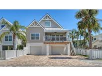 Charming coastal home with a white fence, upper deck, two-car garage and a brick paver driveway at 5007 2Nd Ave, Holmes Beach, FL 34217