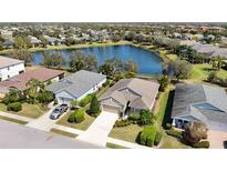 Beautiful aerial view of a lakeside home with manicured lawns and mature trees in a quiet neighborhood at 5011 Kincaid Park Ln, Bradenton, FL 34211