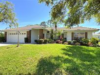 Charming single-story home with a well-manicured lawn, beautiful landscaping, and a two-car garage at 5906 Garden Lakes Majestic, Bradenton, FL 34203