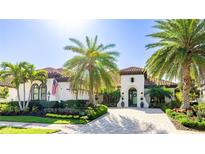 Stunning single-story home with a tile roof, lush landscaping, and a beautiful brick driveway at 7211 Prestbury Cir, Lakewood Ranch, FL 34202