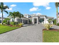 Stunning two-story home featuring a manicured lawn and welcoming entrance with a gray driveway at 8281 Redonda Loop, Lakewood Ranch, FL 34202