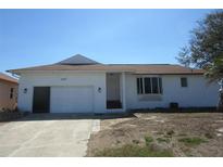 Charming single-story home with a well-maintained lawn, a driveway, and a one car garage on a sunny day at 1027 Newton St, Englewood, FL 34224