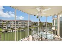 Relaxing screened-in balcony with ceiling fan overlooking a canal with boats and views of the condos at 1250 N Portofino Dr # 303, Sarasota, FL 34242
