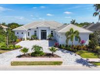 Stunning one-story home with a manicured lawn, circular driveway, and striking black double-door entrance at 16419 Kendleshire Ter, Lakewood Ranch, FL 34202