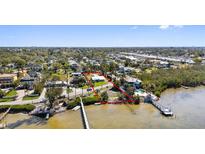 A waterfront property with a pier on a sunny day is outlined in red at 1815 Palma Sola Blvd, Bradenton, FL 34209