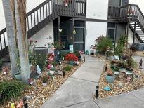 Condominium exterior with multiple plants, flowers, and garden decorations near the walkway at 3784 59Th W Ave # 3784, Bradenton, FL 34210