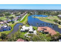 Stunning aerial view of a luxury home on a golf course with lake and lush landscaping at 4002 Las Palmas Way, Sarasota, FL 34238