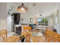 Open-concept living space showcases modern kitchen, dining area, and sunlit living room for seamless entertaining at 4009 Crockers Lake Blvd # 25, Sarasota, FL 34238