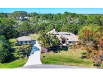 Sprawling home with an oversized driveway and lush landscaping at 4942 Hidden Oaks Ln, Sarasota, FL 34232