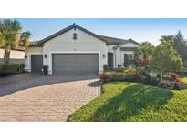 Charming single-story home featuring a brick driveway, mature landscaping, and a spacious three-car garage at 5203 Rushmere Ct, Palmetto, FL 34221