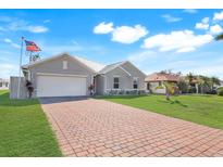 Charming single Gathering home featuring a two-car garage and lush green lawn at 566 Corrientes Cir, Punta Gorda, FL 33983