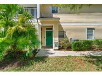 Charming condo featuring a vibrant green front door and lush tropical landscaping at 6320 Rosefinch Ct # 101, Lakewood Ranch, FL 34202