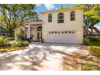 Charming two-story home featuring a manicured lawn, double-door entrance, and an attached two-car garage at 6905 Arbor Oaks Ct, Bradenton, FL 34209