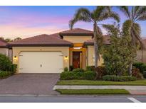 Charming single-story home featuring a tile roof, a two-car garage, and a well-manicured front yard at 108 Maraviya Blvd, Nokomis, FL 34275