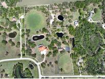 Expansive property featuring multiple ponds, lush greenery, and a beautiful home with an orange tile roof at 1450 & 12001 Bern Creek Loop, Sarasota, FL 34240