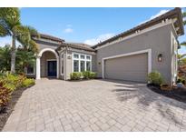 Charming home featuring a paver driveway and manicured landscaping at 14817 Secret Harbor Pl, Lakewood Ranch, FL 34202