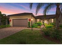 Charming single-story home featuring a tile roof, a brick driveway, and well-maintained landscaping at 17696 Northwood Pl, Lakewood Ranch, FL 34202
