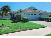 Charming single-story home with a well-manicured lawn, tile roof, and attached two-car garage at 321 Reclinata Cir, Venice, FL 34292