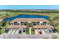 Beautiful aerial view of condo building, lake, and golf course with lush greenery and well-manicured lawns at 5577 Palmer Cir # 203, Bradenton, FL 34211