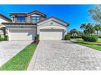 Charming townhome featuring a two-car garage, stone accents, and well-manicured landscaping at 5931 Wake Forest Run # 104, Bradenton, FL 34211