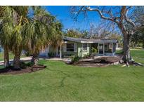 Charming single-story home with lush lawn, mature trees, and a tranquil setting at 640 Fox St, Longboat Key, FL 34228