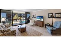 Well-lit living room featuring comfortable seating, stylish decor, and sliding glass doors that open to a balcony at 6804 Gulf Dr # 6804, Holmes Beach, FL 34217