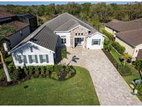 Stunning aerial view of home featuring landscaped yard and paver driveway at 7095 Tamworth Pkwy, Sarasota, FL 34241