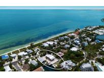 Breathtaking aerial view of the charming waterfront property with lush greenery and stunning ocean backdrop at 807 S Bay Blvd, Anna Maria, FL 34216