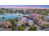 Exterior view of home showcasing waterfront access, lush landscaping, and picturesque sunset at 810 Siesta Dr, Sarasota, FL 34242