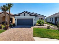 Charming single-story home with a tile roof, brick paver driveway, and well-maintained landscaping at 11522 Trivio Ter, Palmetto, FL 34221