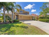 Stunning two-story home with a well-manicured lawn, tall palm trees and a large driveway leading to a spacious garage at 12420 Aster Ave, Bradenton, FL 34212