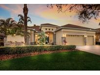 Beautiful, upgraded exterior featuring a manicured lawn and lush tropical landscaping at 13414 Goldfinch Dr, Lakewood Ranch, FL 34202