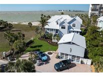 Breathtaking aerial view of coastal home with lush landscaping, garage and beach access at 137 Big Pass Ln, Sarasota, FL 34242