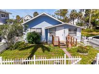 Charming blue home with a white picket fence and well-maintained front yard at 1704 Ballard Park Dr, Bradenton, FL 34205