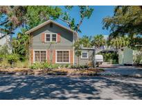 Charming two-story home featuring a unique design with a well-maintained lawn and beautiful trees at 1739 Oak St, Sarasota, FL 34236