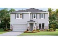 Inviting two-story home featuring a stone-accented garage, gray siding and a well manicured lawn at 18312 Thistleberry Pl, Lakewood Ranch, FL 34211